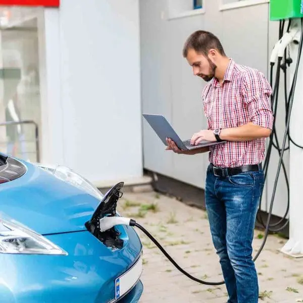 homme-devant-voiture-electrique-avec-ordinateur