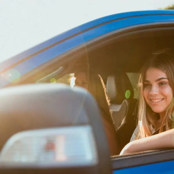 jeune file dans une voiture bleu avec sa mère