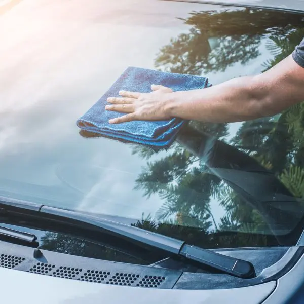 homme-nettoyant-le-pare-brise-de-sa-voiture