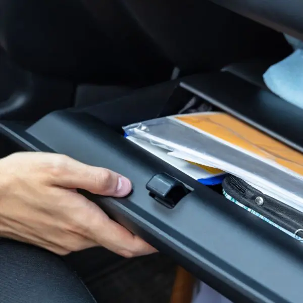 personne qui ouvre la boite à gant pour trouver des documents