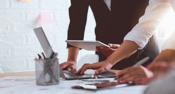 deux personnes qui consultent un ordinateur et une tablette